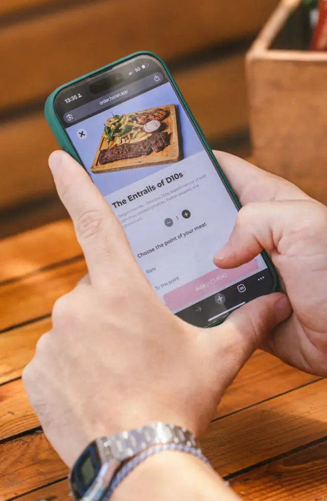 Un cliente elige un plato en la carta de honei desde su móvil, con el QR en la mesa